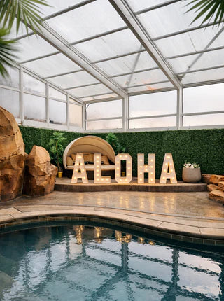 Indoor pool area with 'Aloha' sign and decorative elements.